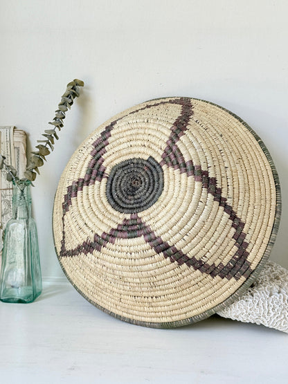 Large hand woven coiled basket with three point star pattern, natural fibre and dark geometric detail for wall or table styling