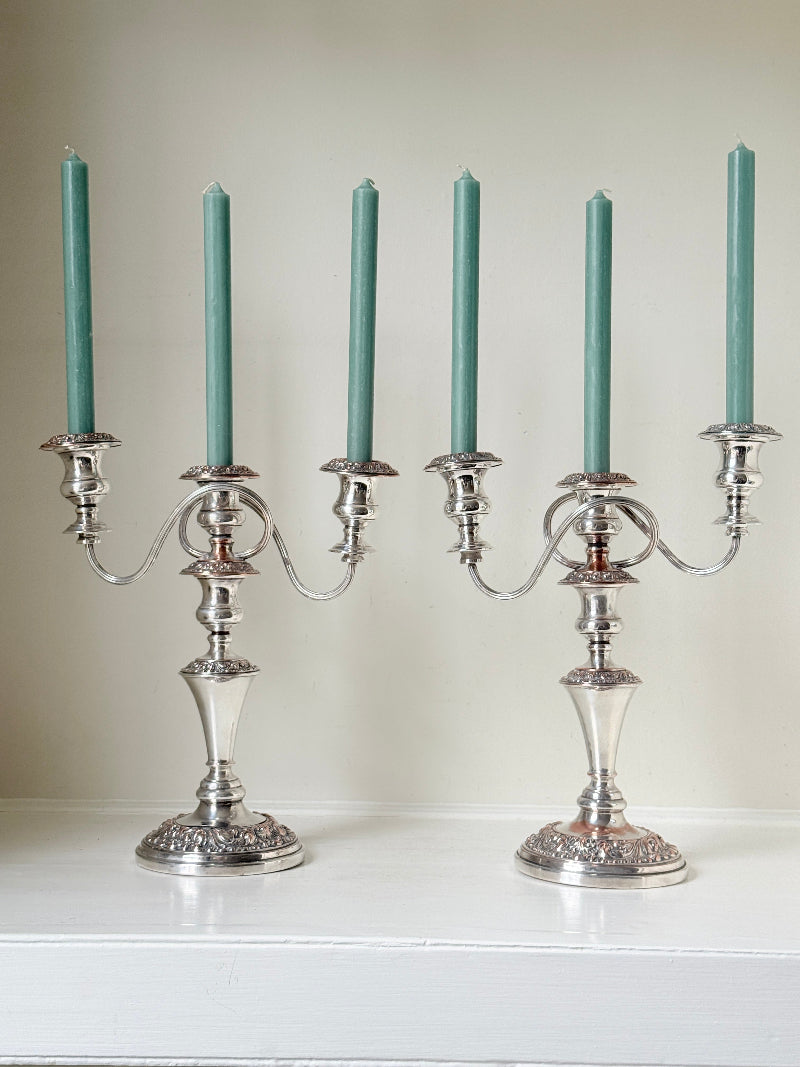 Pair of convertible silver plate on copper candelabra with repoussé detail, removable arms and green taper candles