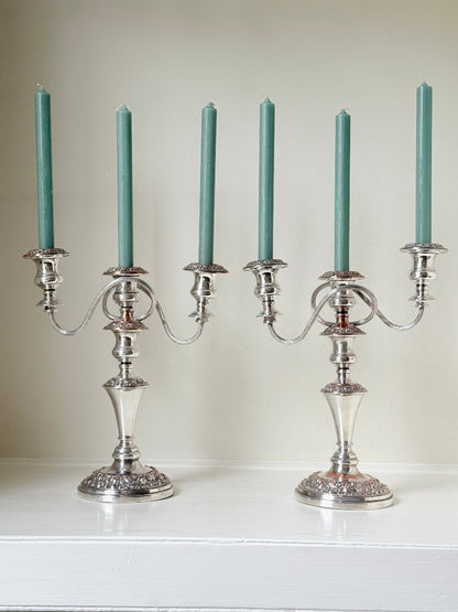 Pair of convertible silver plate on copper candelabra with repoussé detail, removable arms and green taper candles