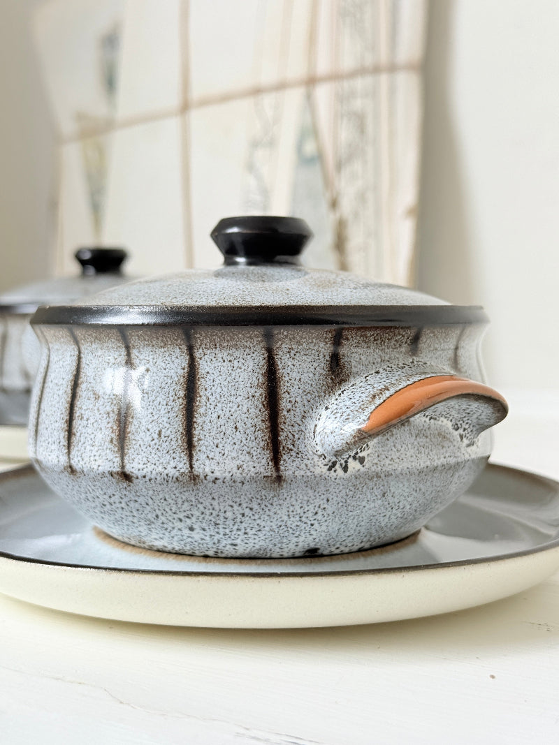 Denby Studio pair of lidded soup bowls with stands in grey and rust photographed on a white surface