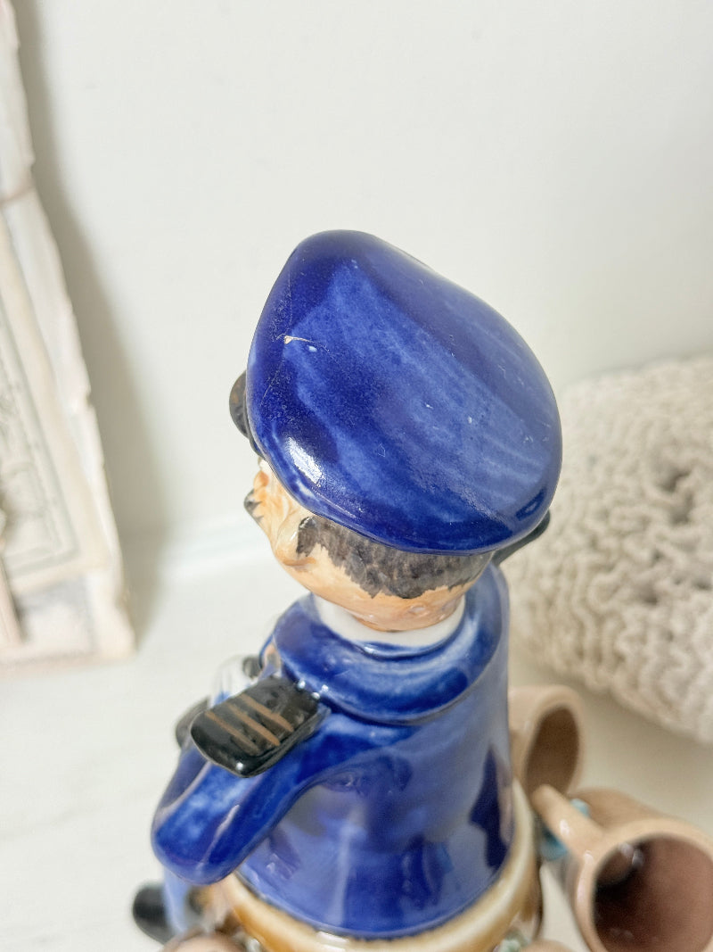 Vintage figural ceramic decanter set with captain, navy blue uniform, barrel base and 6 matching barrel shot cups