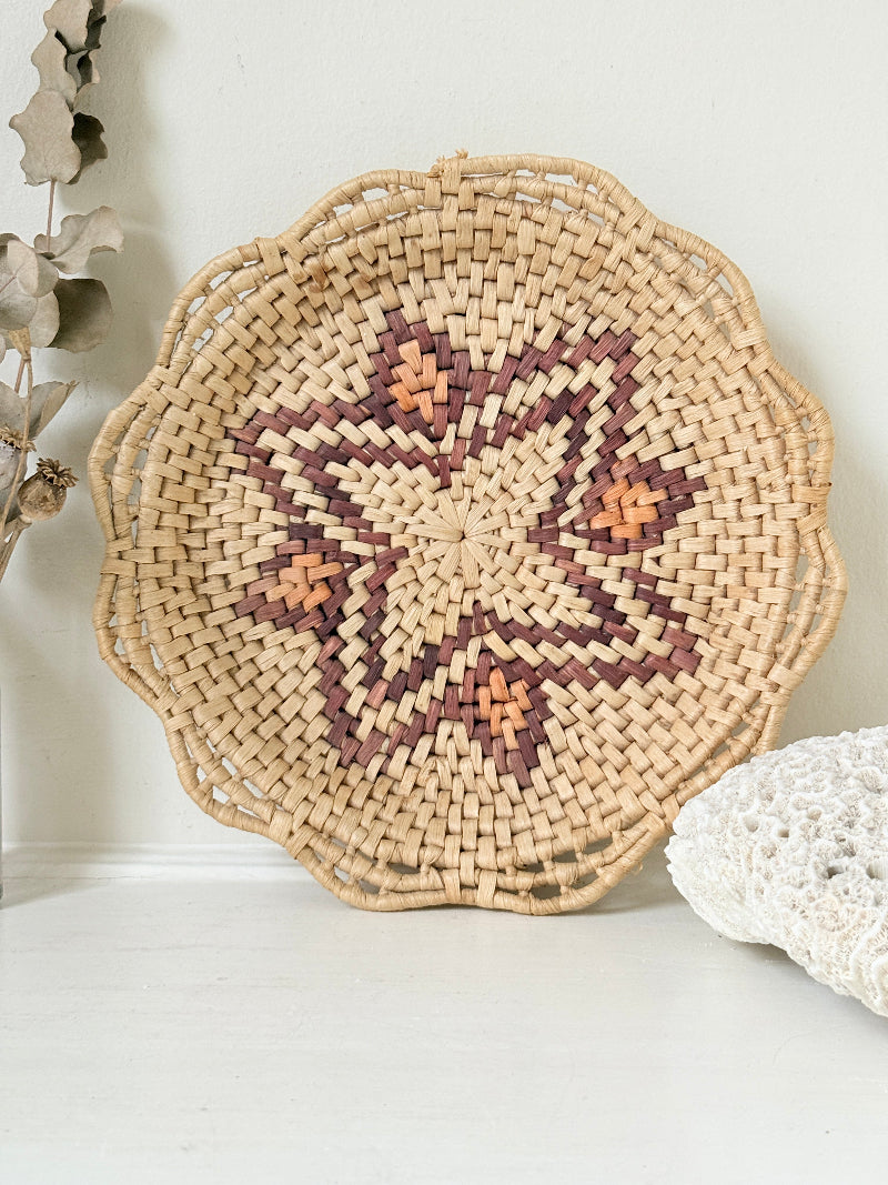 Vintage woven basket tray with star motif photographed on a white surface