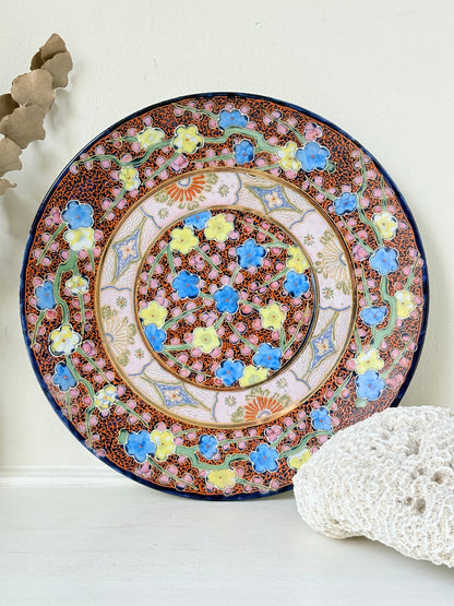 Antique Japanese Aoki Brothers platter with colourful Imari style floral pattern photographed on a white surface