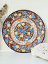 Antique Japanese Aoki Brothers platter with colourful Imari style floral pattern photographed on a white surface
