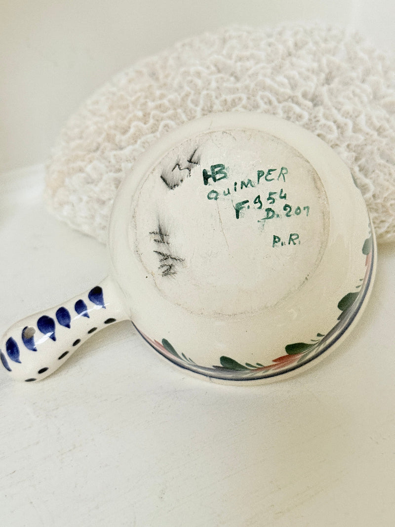 French Quimper faience handled olive bowl with Petit Breton figure and blue rim, photographed on a white surface
