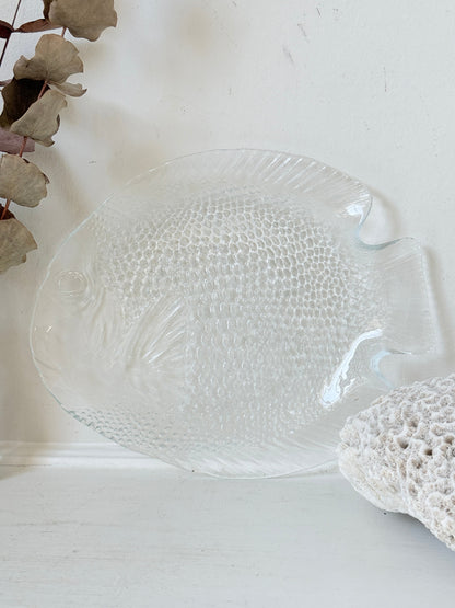 Vintage clear glass fish shaped serving dish with textured scale pattern photographed on a white surface