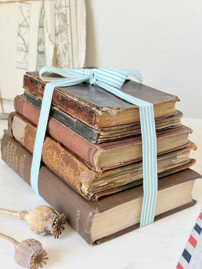 Vintage decorative brown book bundle with aged hardback covers tied with blue stripe ribbon for bookshelf and table styling
