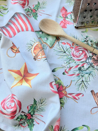 Blue Loft Christmas cotton tea towel with red striped stocking and festive motif pattern photographed on a white worktop.