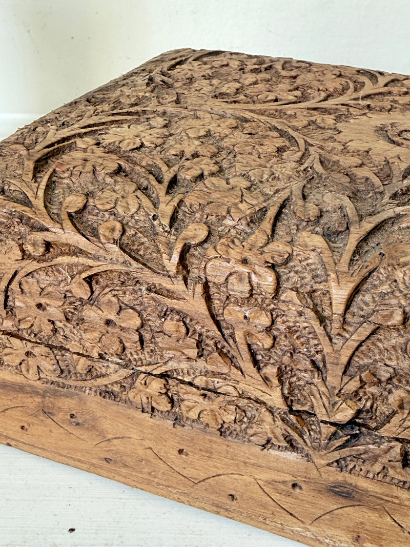 Vintage hand carved wooden jewellery box with floral detail and red fabric lining, photographed on a white surface