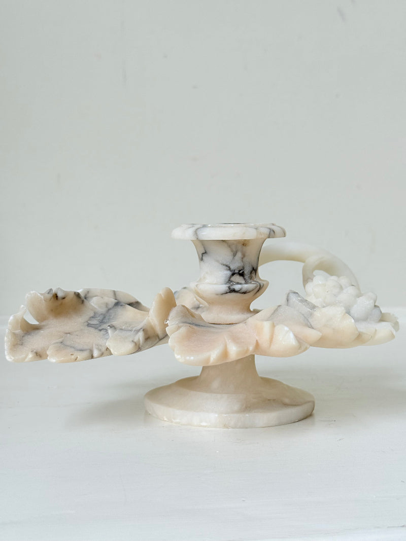 Antique alabaster marble floral candleholder with carved leaves and flowers, photographed on a white surface.