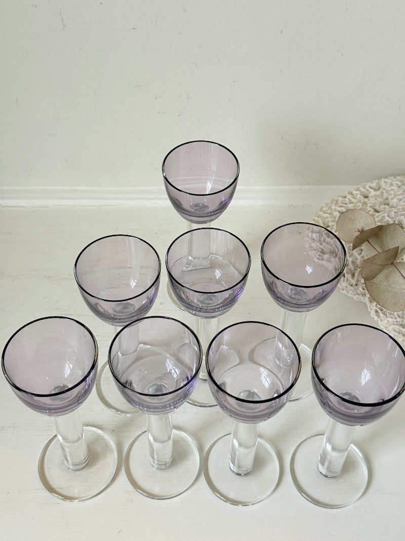 Set of 8 vintage lilac tinted liqueur glasses on a white surface