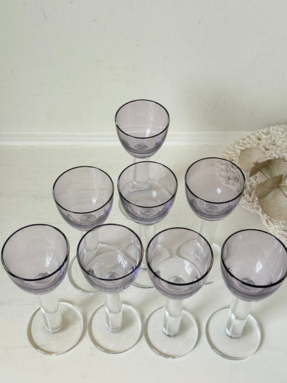 Set of 8 vintage lilac tinted liqueur glasses on a white surface