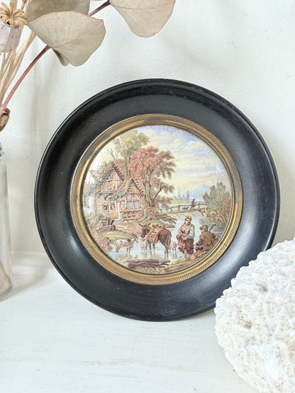 Antique Prattware framed pot lid with cottage scene photographed on a white surface.