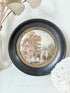 Antique Prattware framed pot lid with cottage scene photographed on a white surface.