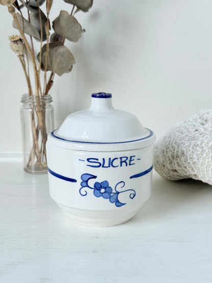 Vintage French blue and white studio pottery sugar bowl with lid, photographed on a white surface.
