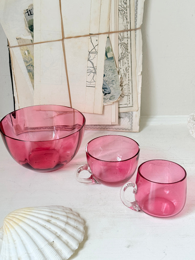 Trio of antique cranberry glass with sugar bowl, teacup, coffee can, clear glass handles and deep pink glass
