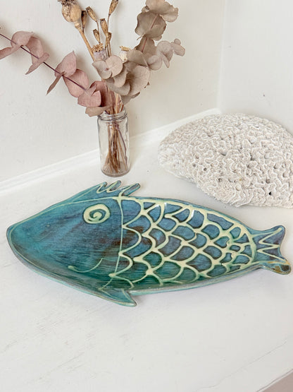 Barbados studio pottery fish platter in turquoise and sea green glaze photographed on a white surface