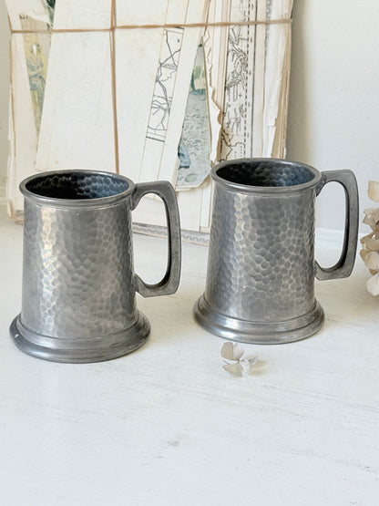 Pair of hammered English pewter tankards by E H Parkin of Sheffield, photographed on a white surface