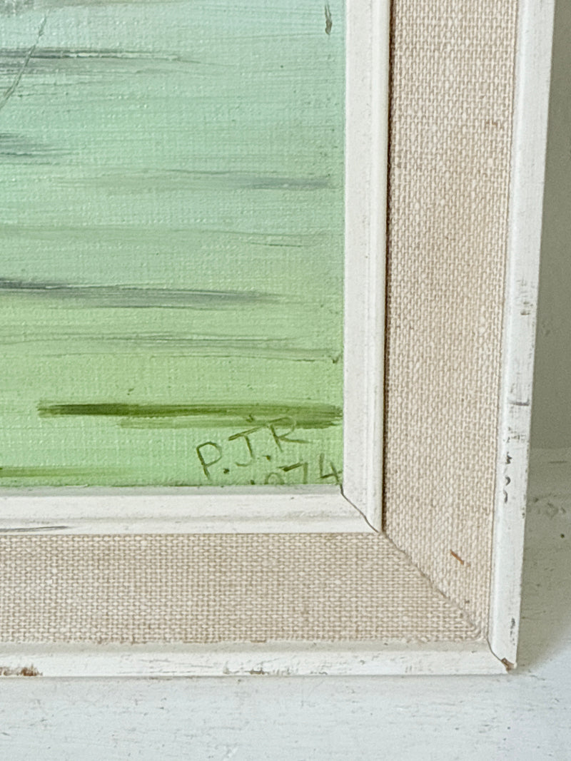 Close-up of a framed painting showing a textured light green painted panel with a white distressed frame and beige linen-like canvas backing.