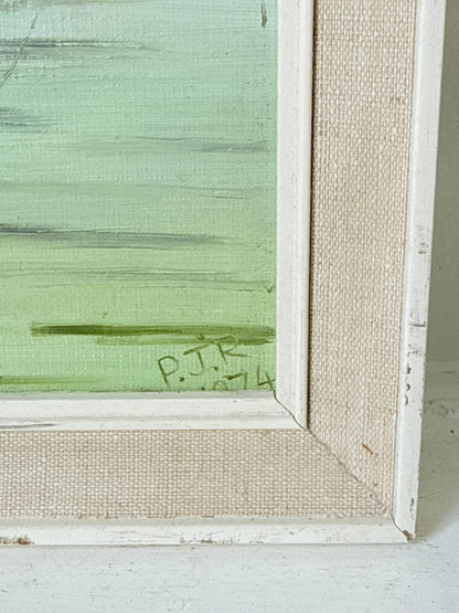 Close-up of a framed painting showing a textured light green painted panel with a white distressed frame and beige linen-like canvas backing.