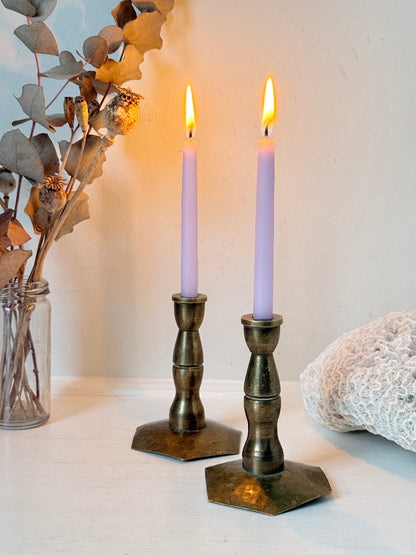 Pair of miniature brass candlesticks with hex bases photographed on a white surface