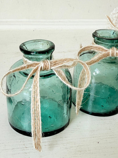 Set of antique green glass ink bottles with rounded forms, photographed on white surface.