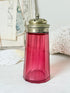 Antique cranberry glass sugar shaker with ribbed optic body, pierced metal top, star holes and deep pink glass