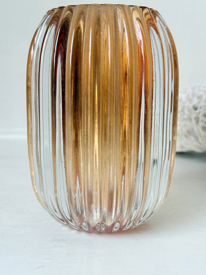 Vintage ribbed amber brown glass vase photographed on a white surface