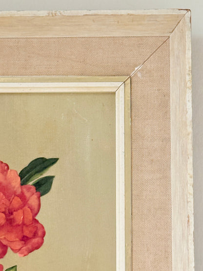 Close-up of a framed floral artwork corner, showing a light wood frame, beige fabric mat, and part of a red flower with green leaves on a beige background.