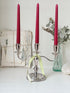 Silver plate three light candelabra with curved arms and domed base holding red taper candles