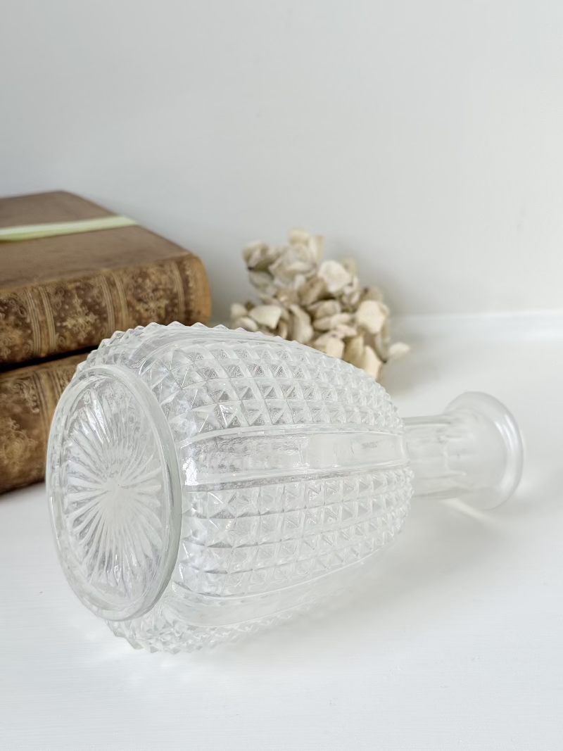 Vintage clear glass vase with textured surface, styled with dried flowers on a white background