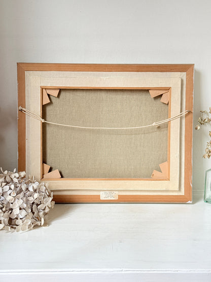 The back of a wooden picture frame with a linen canvas backing, displayed on a white surface against a light gray wall.