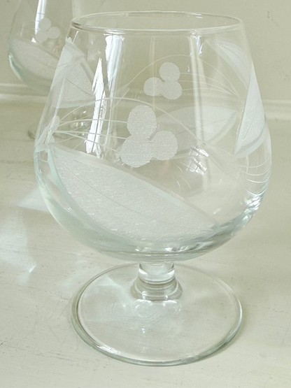 Set of six vintage etched Bailey’s glasses with rounded bowls and short stems, photographed on white surface.