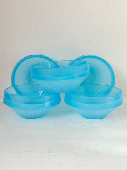 Set of six vintage turquoise midcentury glass bowls with smooth sides, photographed on white surface.