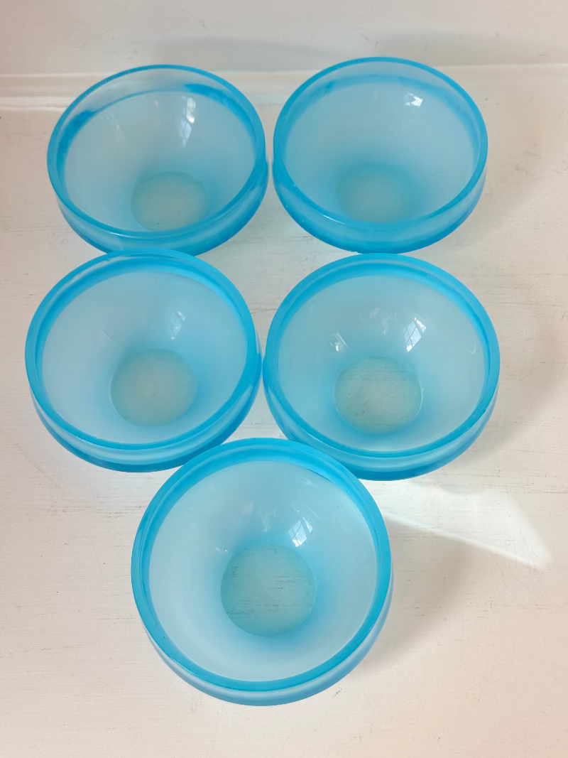 Set of six vintage turquoise midcentury glass bowls with smooth sides, photographed on white surface.