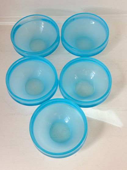 Set of six vintage turquoise midcentury glass bowls with smooth sides, photographed on white surface.