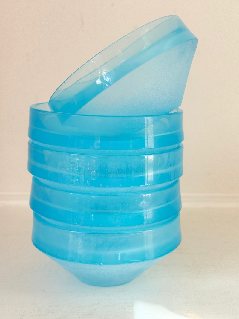 Set of six vintage turquoise midcentury glass bowls with smooth sides, photographed on white surface.