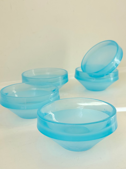 Set of six vintage turquoise midcentury glass bowls with smooth sides, photographed on white surface.