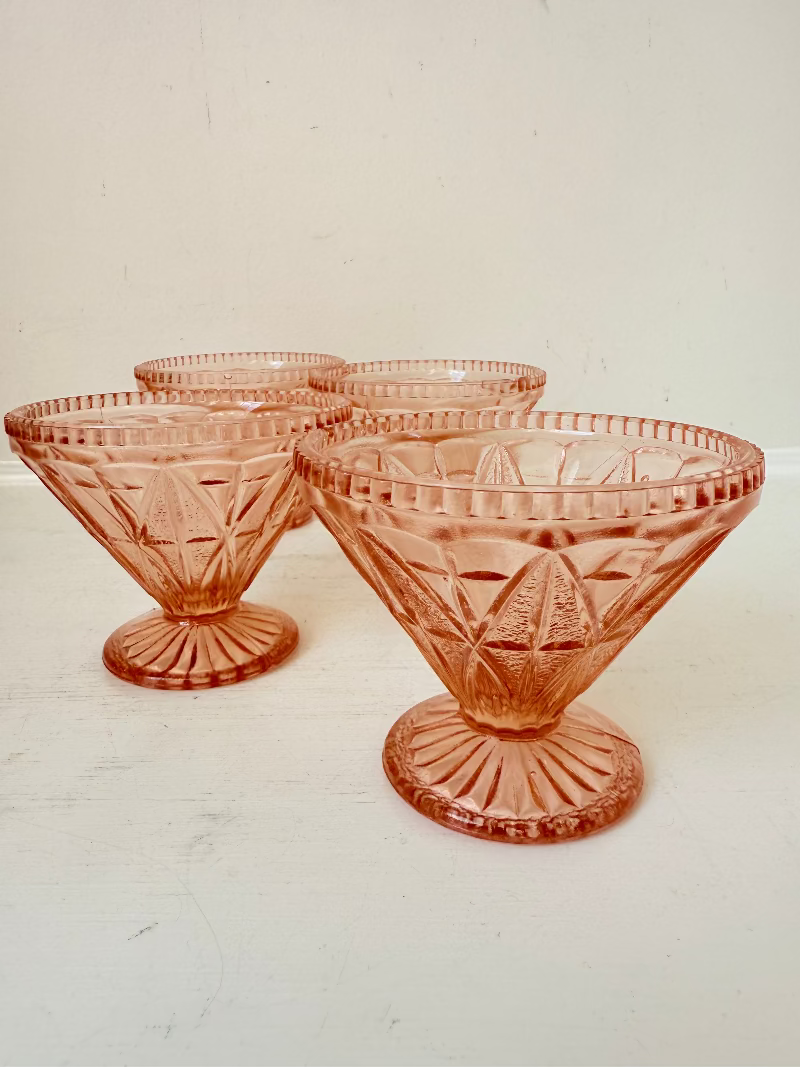 Set of four vintage pressed glass coral dishes with geometric pattern and flared form, photographed on white surface.