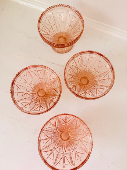 Set of four vintage pressed glass coral dishes with geometric pattern and flared form, photographed on white surface.