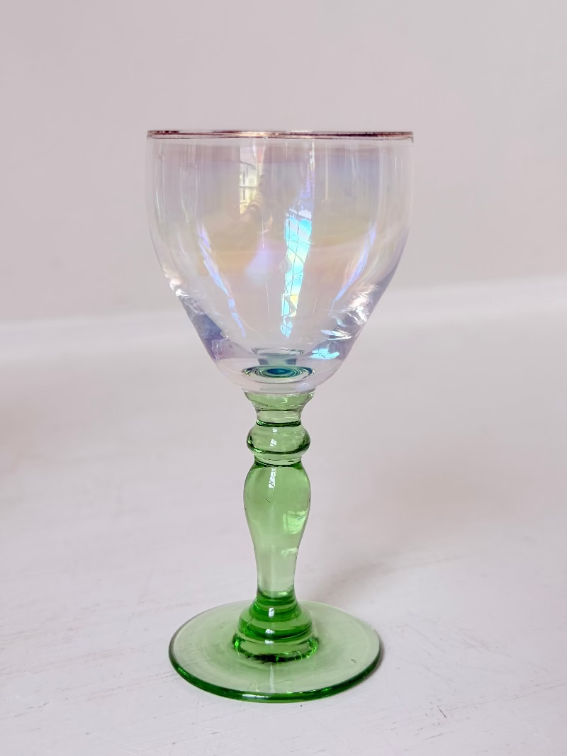 Vintage trio of iridescent shot glasses with green stems and gilt rims, photographed on a white surface