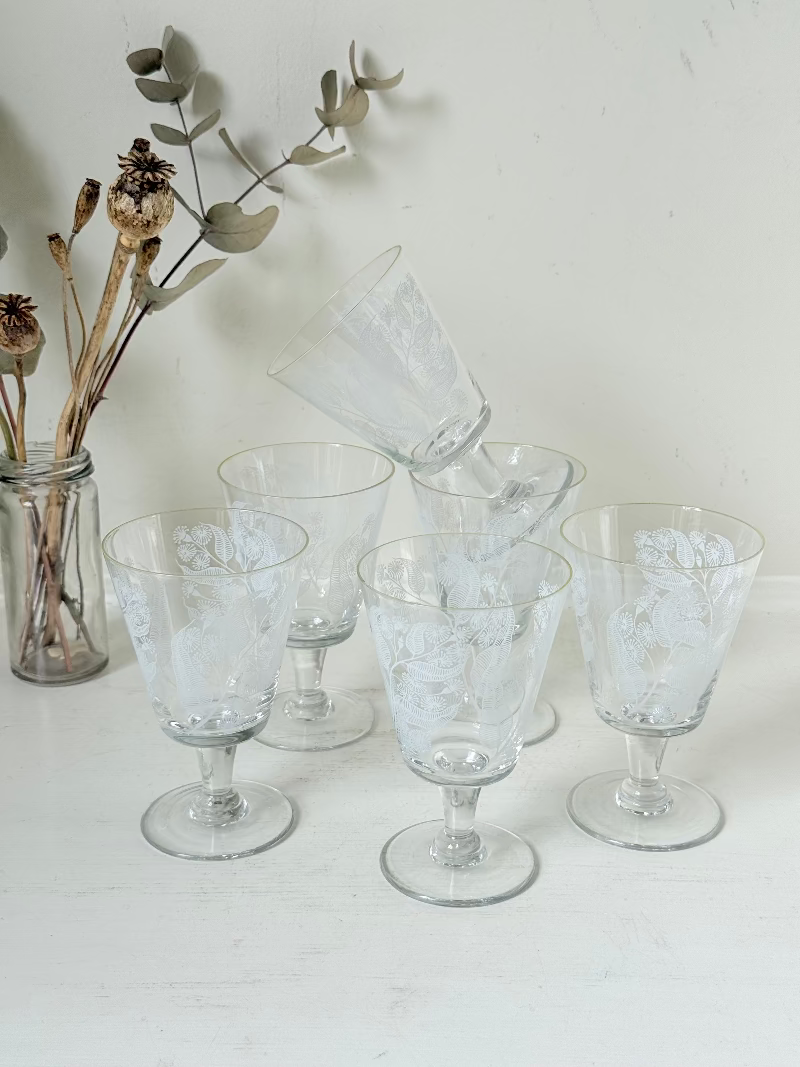 Set of six vintage wine glasses with white floral printed design, photographed on white surface.
