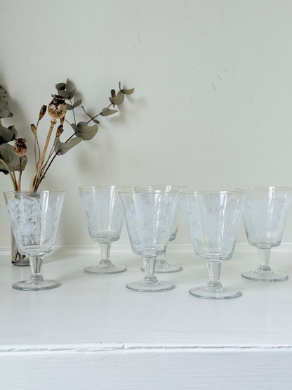 Set of six vintage wine glasses with white floral printed design, photographed on white surface.