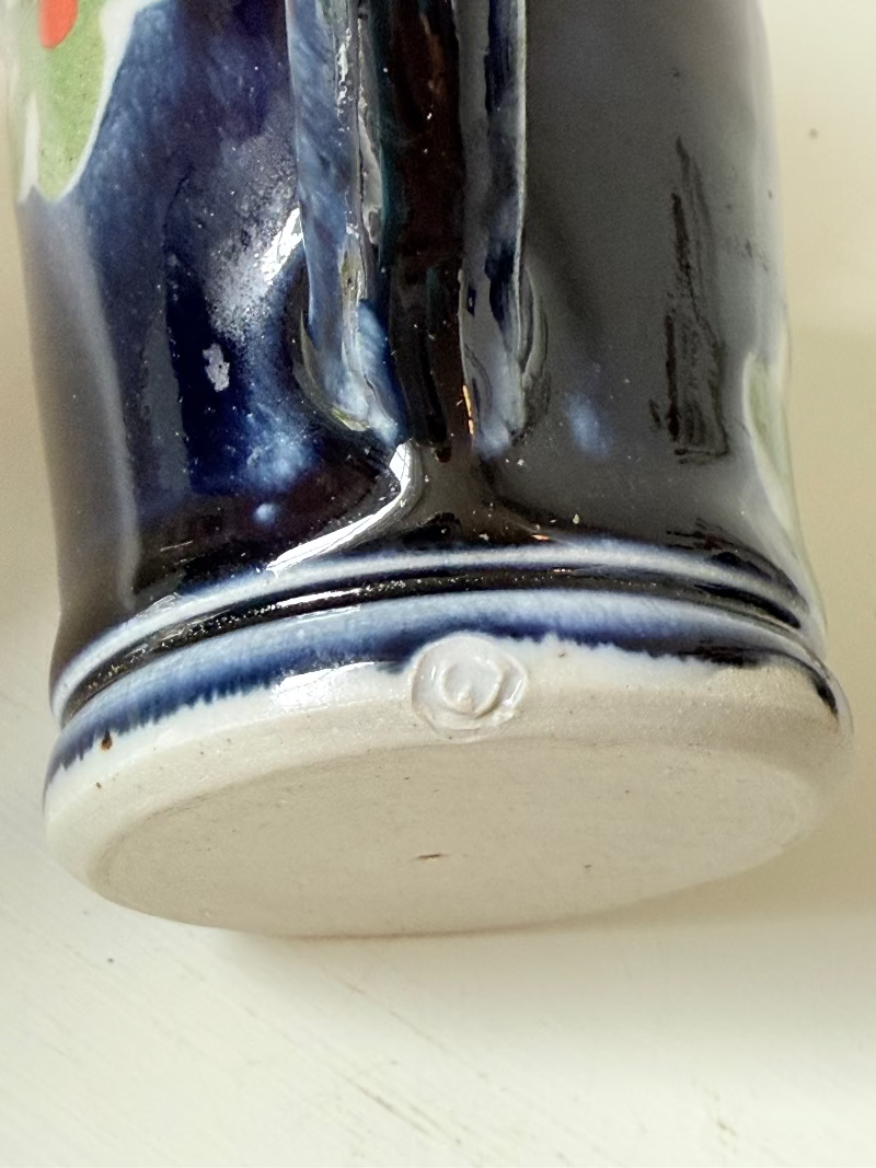 Vintage studio pottery coffee cans with matching saucers in navy glaze and floral motifs, set of four, photographed on a white surface