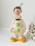 vintage ceramic clown moneybox with green and yellow painted details on white surface