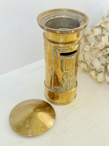 vintage brass post box moneybox with vr emblem photographed on white surface