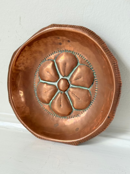 small vintage copper dish with cut-out floral centre photographed on white surface