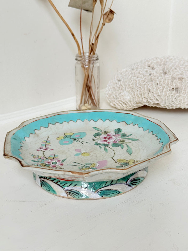 Antique ceramic footed dish with turquoise floral and bird design, photographed on a white surface.