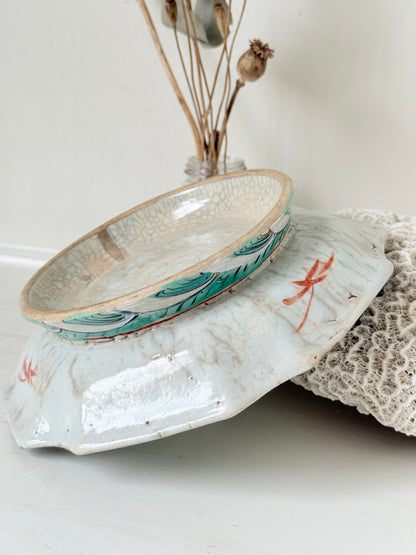 Antique ceramic footed dish with turquoise floral and bird design, photographed on a white surface.