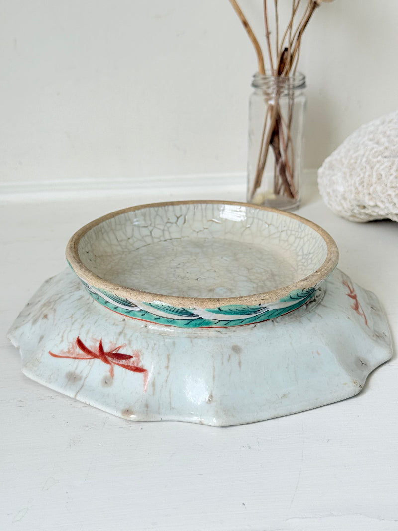 Antique ceramic footed dish with turquoise floral and bird design, photographed on a white surface.